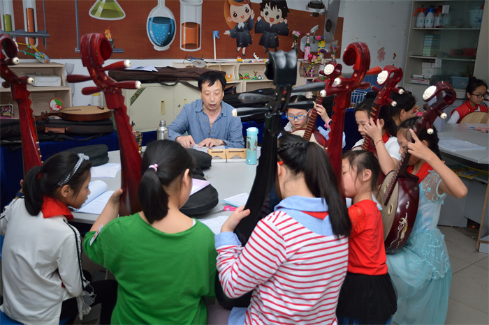 传承(组图3)2019.4.24连江县琯头镇 为了让孩子更好的掌握民族乐器演奏技巧,学校特聘民间老艺人进校传授弹拨乐知识.jpg