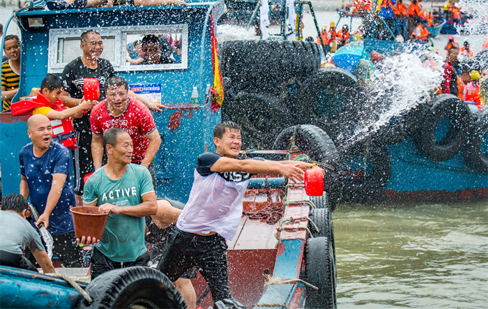 两岸对渡泼水节(组图3)2019年6月7日在福建石狮市蚶江镇拍摄 两岸对渡海上泼水节 宽阔的海面上百舸竞逐嬉戏,渔船在海上旋绕,船上人们尽情欢呼,以泼水互相祝福。.jpg